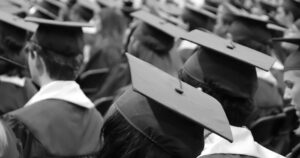 Students seated in graduate cap and gowns